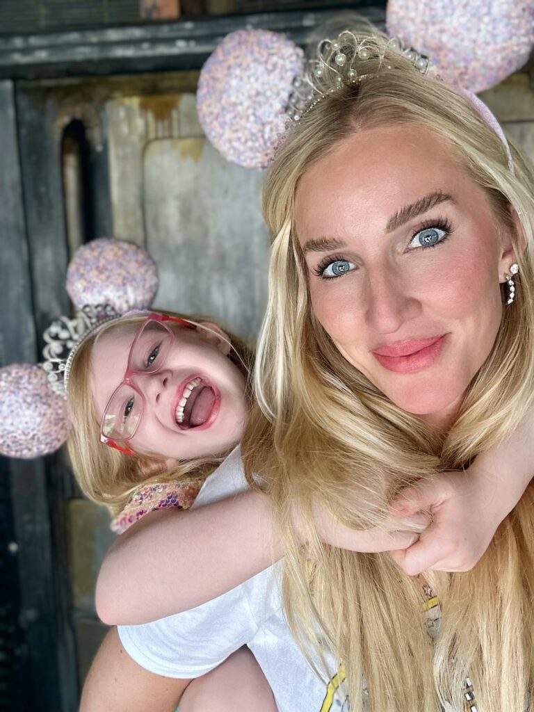 Jessica and her Daughter Henley smiling in matching pink and sparkly Mickey Mouse Ears